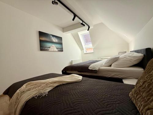 a bedroom with two beds and a painting on the wall at Allvia apartment in Trnava