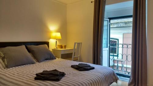 een slaapkamer met een bed met twee handdoeken erop bij Casa da Alma - Alfama in Lissabon