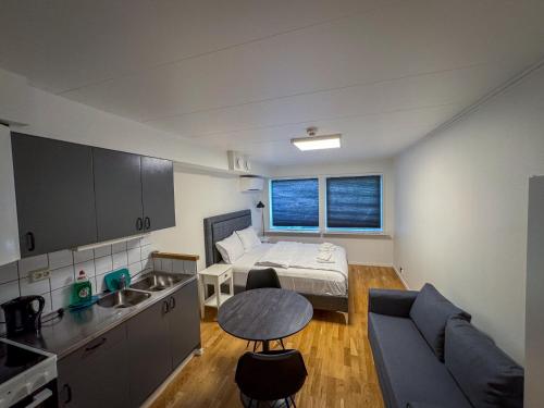 a small room with a bed and a couch and a kitchen at Injoy Classic Hotel Elmia in Jönköping