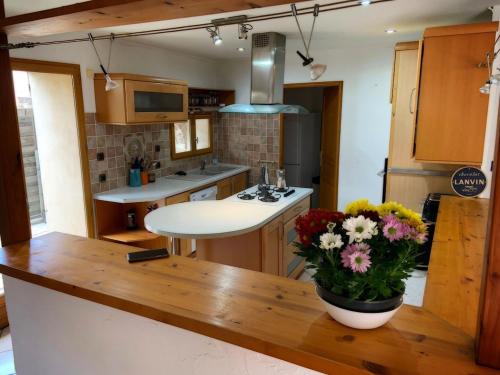 a kitchen with a table with a vase of flowers on it at Ceret Beautiful Spacious House & Courtyard BBQ in Céret