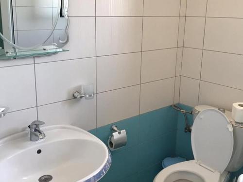 サランダにあるVila shabaniの白いトイレと洗面台のあるバスルーム