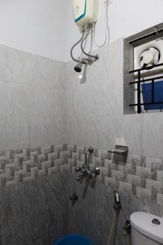 a bathroom with a shower with a toilet and a light at Stay Above by Alchemy Homes in Cochin