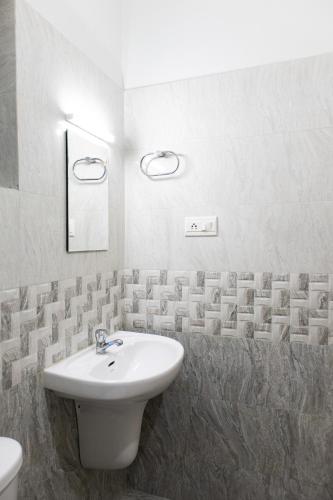 a white bathroom with a sink and a toilet at Stay Above by Alchemy Homes in Cochin