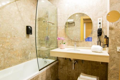 a bathroom with a tub and a sink and a mirror at Cullera Holiday in Cullera