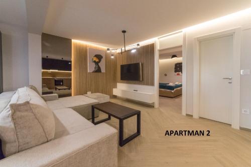 a living room with a white couch and a tv at Vule Vu Collection in Bajina Bašta