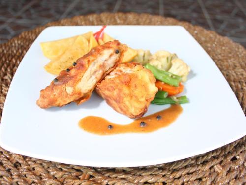 een witte plaat met eten op tafel bij Dream Beach Kubu & SPA by ABM in Nusa Lembongan