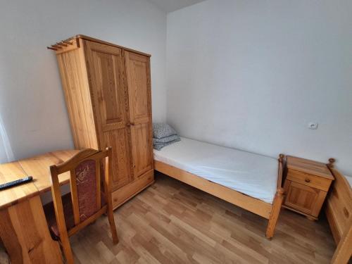 Habitación pequeña con cama y armario de madera. en Bursztynowy Brzeg, en Gąski