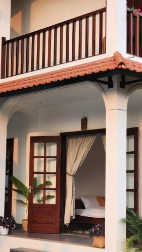 a bed in a house with a balcony at Anio Ha Giang Hotel in Ha Giang