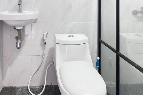 a bathroom with a white toilet and a sink at Niti Stay Syariah near Stasiun Wates RedPartner in Wates