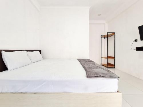 a white bedroom with a large white bed at Niti Stay Syariah near Stasiun Wates RedPartner in Wates
