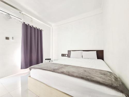 a white bedroom with a large bed and a window at Niti Stay Syariah near Stasiun Wates RedPartner in Wates