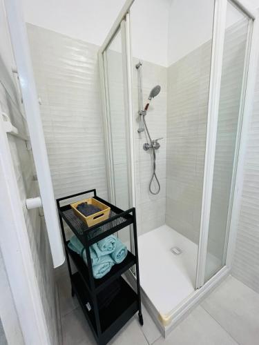une salle de bain avec douche et un chariot noir avec des serviettes dans l'établissement Studio centre ville parking privé Clim et wifi, à Saint-Raphaël