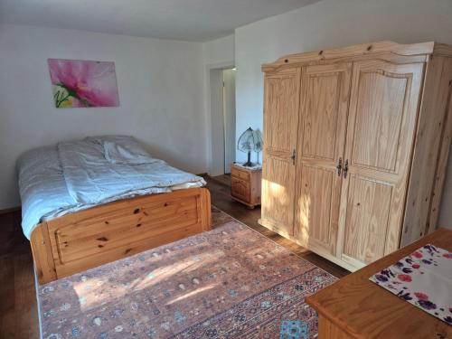 a bedroom with a bed and a wooden cabinet at Ferienwohnung beim Imker in Hohenstein
