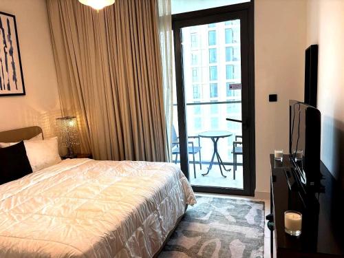 a bedroom with a bed and a balcony with a table at Palm View Marina Vista 1BR Beachfront in Dubai