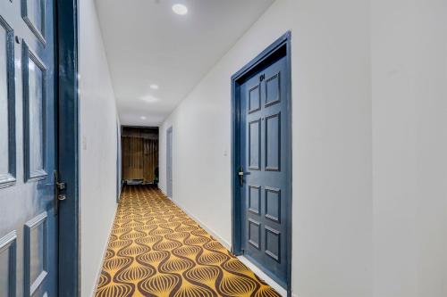an empty hallway with an open door with a patterned floor at Hotel O Ritz Rivera in New Delhi