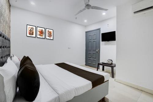 a bedroom with a bed and a flat screen tv at Hotel O Ritz Rivera in New Delhi