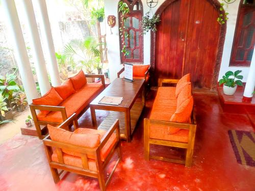 a living room with chairs and a wooden table at Breeze Guest House in Trincomalee