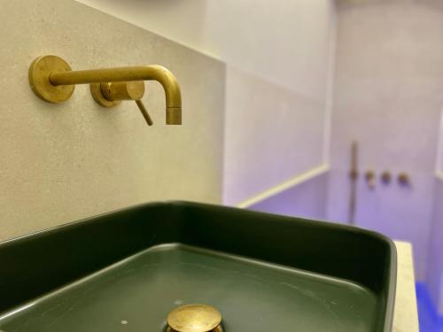 a kitchen sink with a gold faucet and a sink at I Granai, dimora con vasca idromassaggio - Marea Stays Collection in Nardò