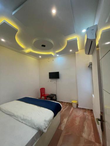 a bedroom with a bed and a flat screen tv at The urban inn Hotel in Lucknow