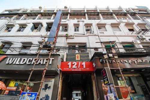 a tall white building with a sign in front of it at Hotel O A One Guest House in Kolkata