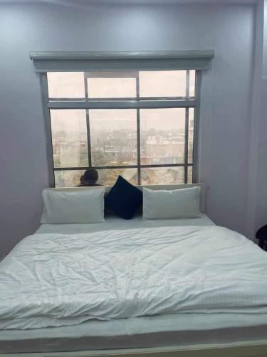 a bed in a room with a large window at The urban inn Hotel in Lucknow