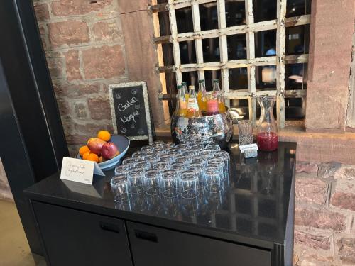 a table with wine glasses and a bowl of fruit at Hotel Liberty Offenburg in Offenburg