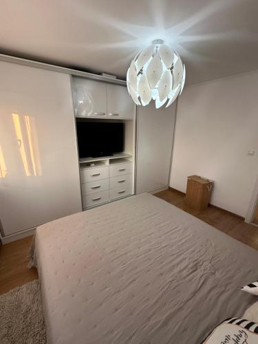 a bedroom with a large bed and a television at Central apartment in Carei
