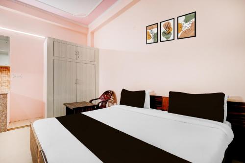 a bedroom with a black and white bed and a chair at SPOT ON Hotel Dezire Dhankot Chowk in Gurgaon
