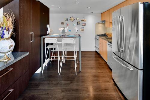 a kitchen with a table and a refrigerator at Trendy Downtown Loft Apartment - King Bed! in Vancouver