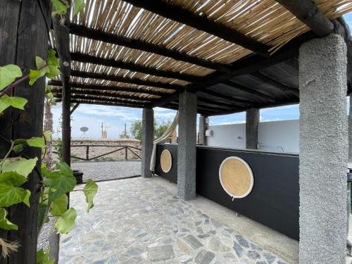 a patio with a wooden pergola at Casa Crisantemo with sea view and pool in Adra in Las Hoyas del Barranco