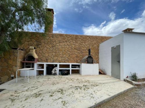 a building with a stone wall and a white counter at Casa Crisantemo with sea view and pool in Adra in Las Hoyas del Barranco
