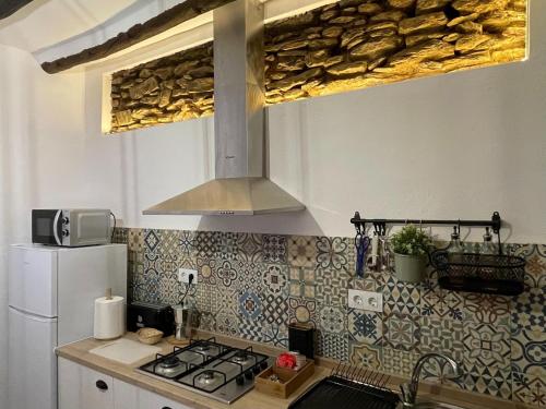 a kitchen with a stove top oven next to a refrigerator at Casa Crisantemo with sea view and pool in Adra in Las Hoyas del Barranco