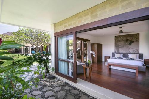 ウルワツにあるForever Bali Villasの大きなガラス窓のあるヴィラの寝室