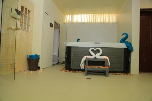 a room with a bath tub with a table and swans at Sunland International Hotel in Kolobo