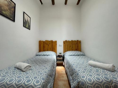 two beds in a room with white walls at Casa Crisantemo with sea view and pool in Adra in Las Hoyas del Barranco