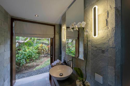 ウルワツにあるForever Bali Villasの洗面台と窓のあるバスルーム