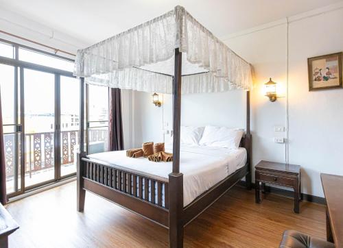 a bedroom with a canopy bed and a balcony at SK Boutique Mahanakhon in Bangkok