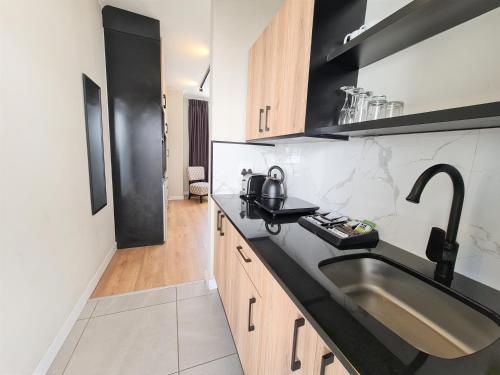 a kitchen with a sink and a black counter top at MINT Hotel 84 on Katherine in Johannesburg