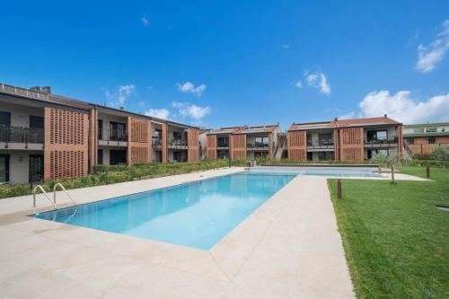 an image of a swimming pool in front of apartment buildings at ApartmentsGarda - Cuore del Garda in Ronchi