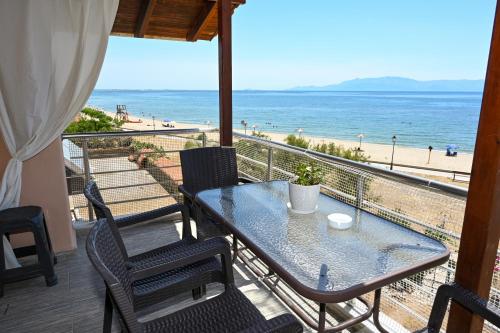 a table and chairs on a balcony with a view of the beach at Blue View in Kavala