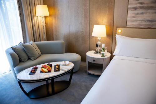 a hotel room with a bed and a table with food on it at Waldorf Astoria Jerusalem in Jerusalem