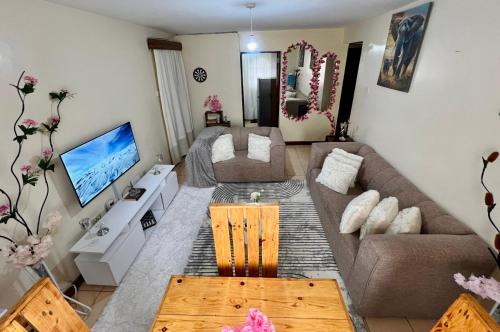 a living room with a couch and a television at Casa Solenda in Ruaka