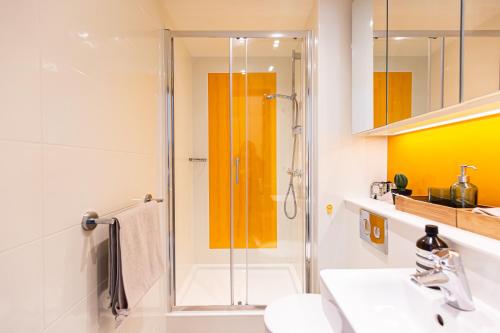 a bathroom with a shower and a sink at New Era Living - Private Rooms next to Bramall Lane in Sheffield