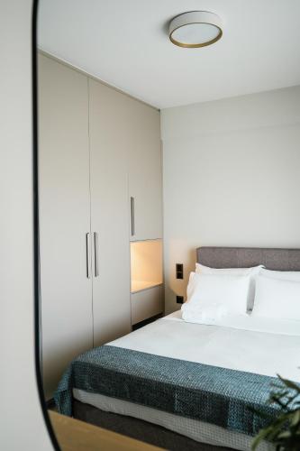 a bedroom with a bed and a mirror at Vardians Villas & Suites in Karistos