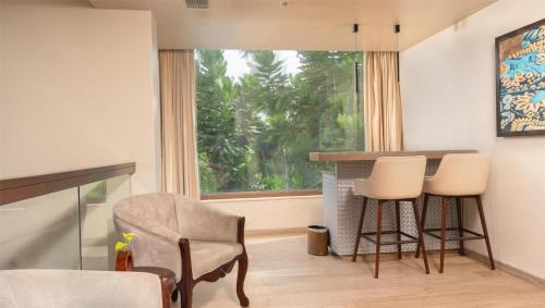 a living room with a table and chairs and a window at Radisson Blu Resort Visakhapatnam in Visakhapatnam