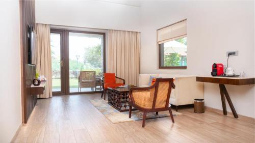 a living room with a table and chairs at Radisson Blu Resort Visakhapatnam in Visakhapatnam