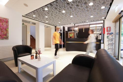 a living room with two men walking in a store at Garconete in Salzburg