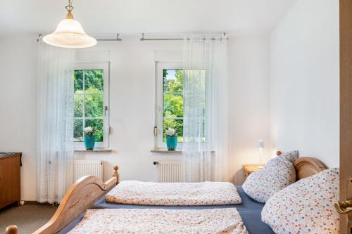 a bedroom with two beds and two windows at Ferienhaus Schenum in Jever