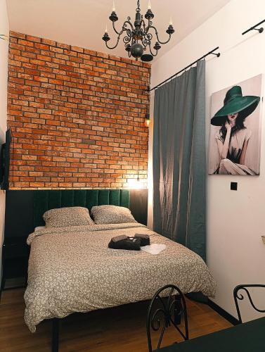 a bedroom with a brick wall and a bed at Rynek Experience - Apartamenty in Gliwice