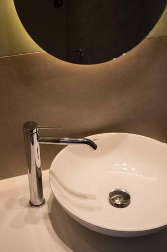 a white bathroom sink with a silver faucet at See2sea Cozy Apartments in Kolymvari